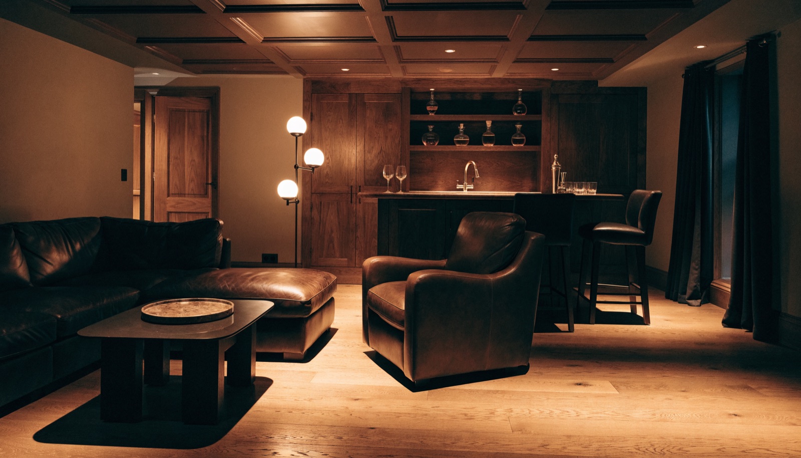 Luxury finished basement lounge with custom bar by ONIT Restoration